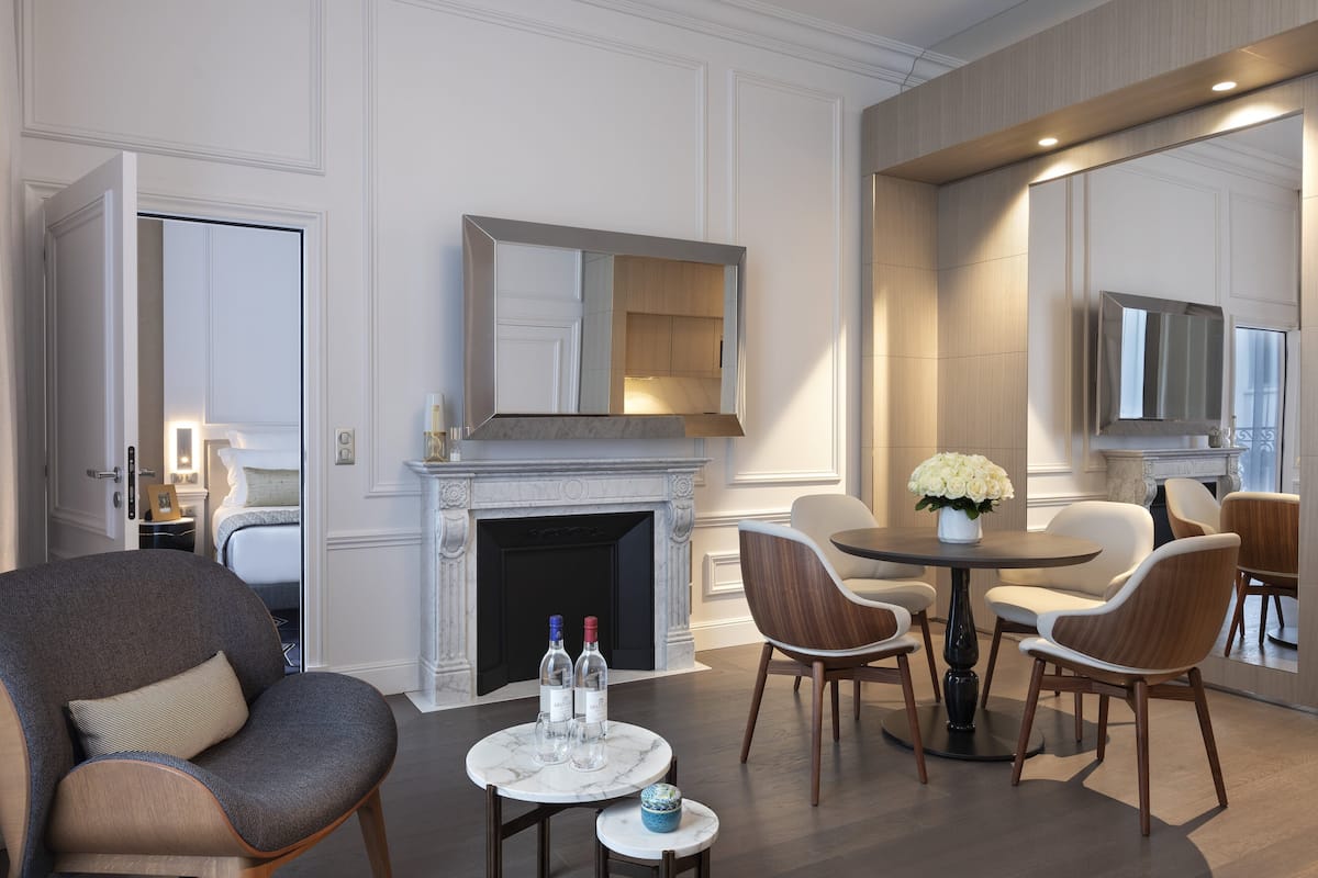 Een moderne woonkamer met een open haard, zithoek en een eettafel.