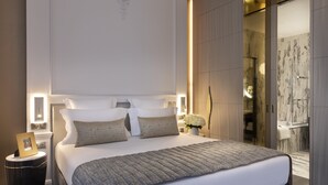 Une chambre à coucher moderne avec un grand lit, des tables de chevet et une petite table de nuit.