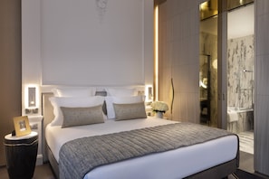 Un dormitorio moderno con una cama grande, mesitas de noche y una mesilla.