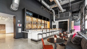 Un área de bar moderna con mostrador, asientos y un detector de incendios visible.