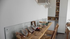A kitchen with a wooden countertop, jars, and a bread display. - Gea apartment Etna (Nicolosi)