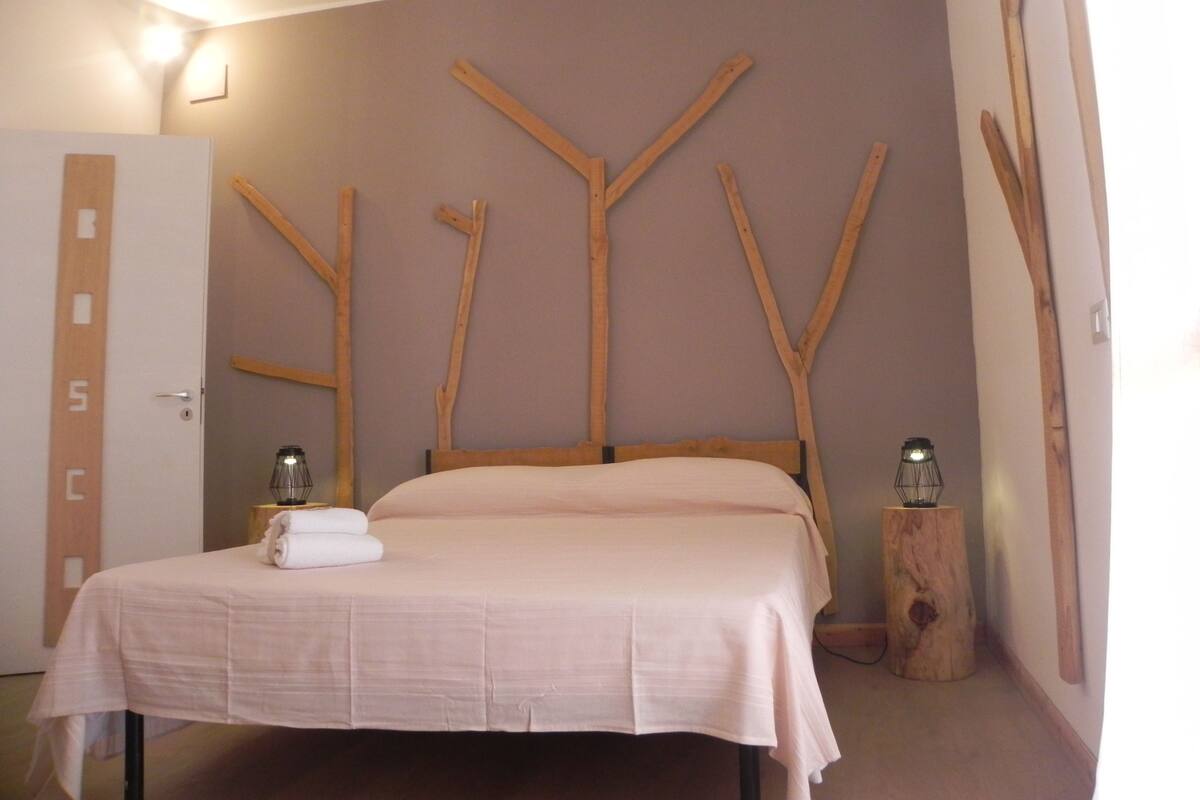 Een slaapkamer met een bed, houten wanddecoratie en een deur met een groeiemeter.