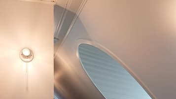 A modern interior with a curved ceiling and a central light fixture.