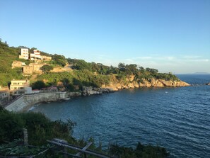Une zone côtière avec des bâtiments situés sur une colline, dominant la mer.
