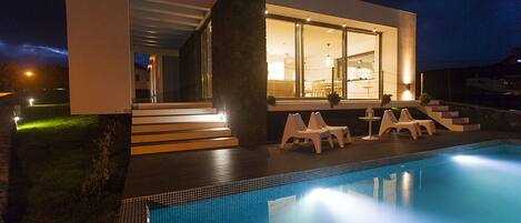 Alberca al aire libre, sombrillas en la alberca y camastros