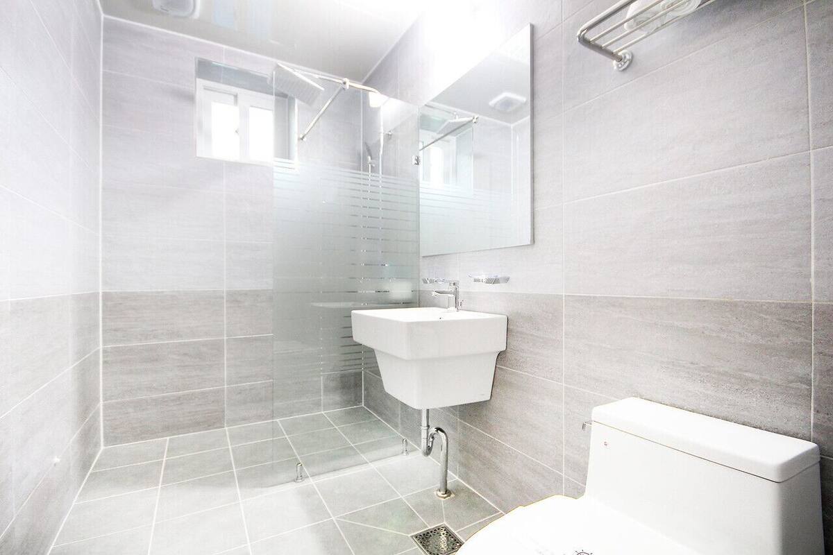 A modern bathroom with a shower, sink, and toilet.