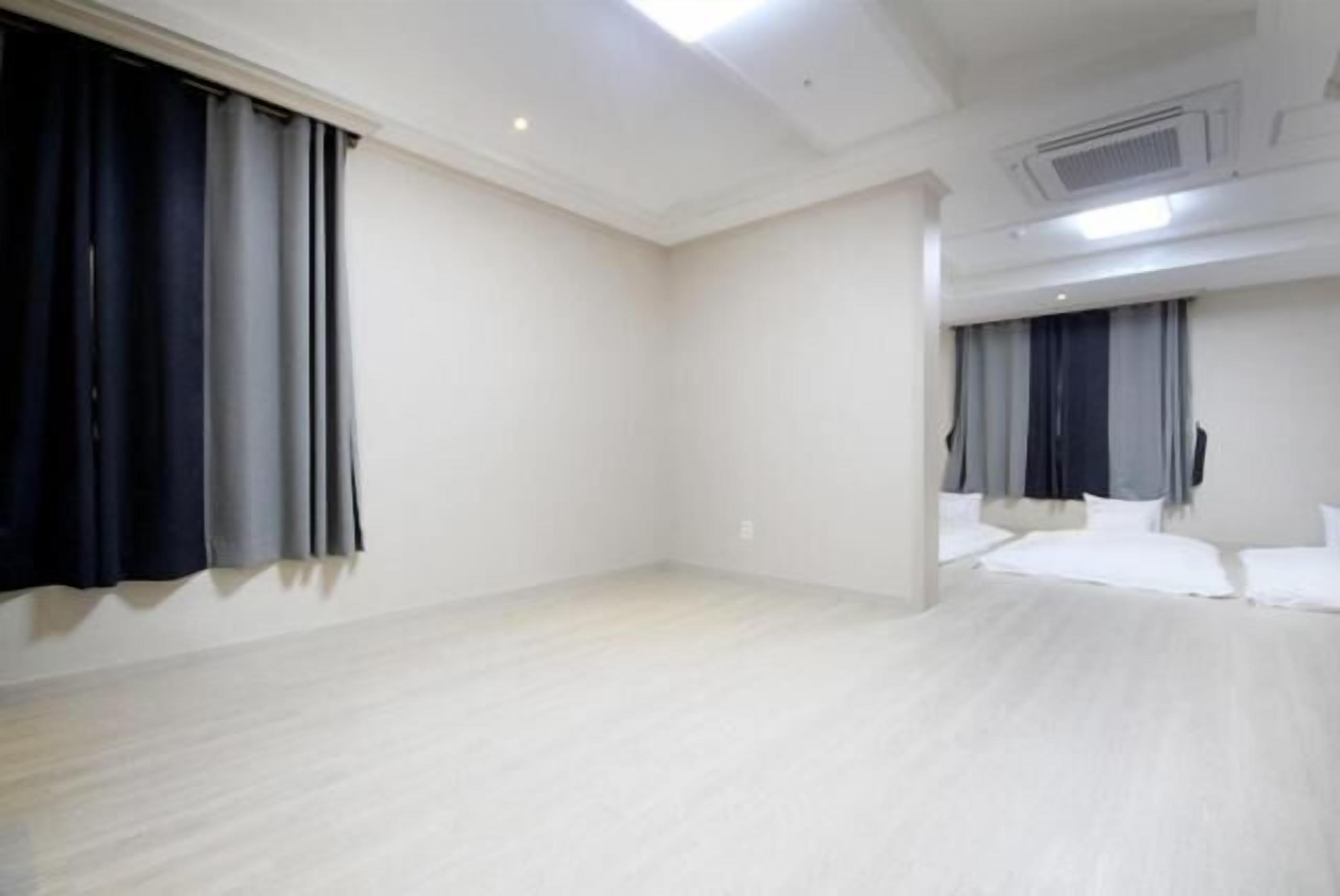 Une chambre d’hôtel avec un grand lit, un téléviseur à écran plat et un ventilateur de plafond.
