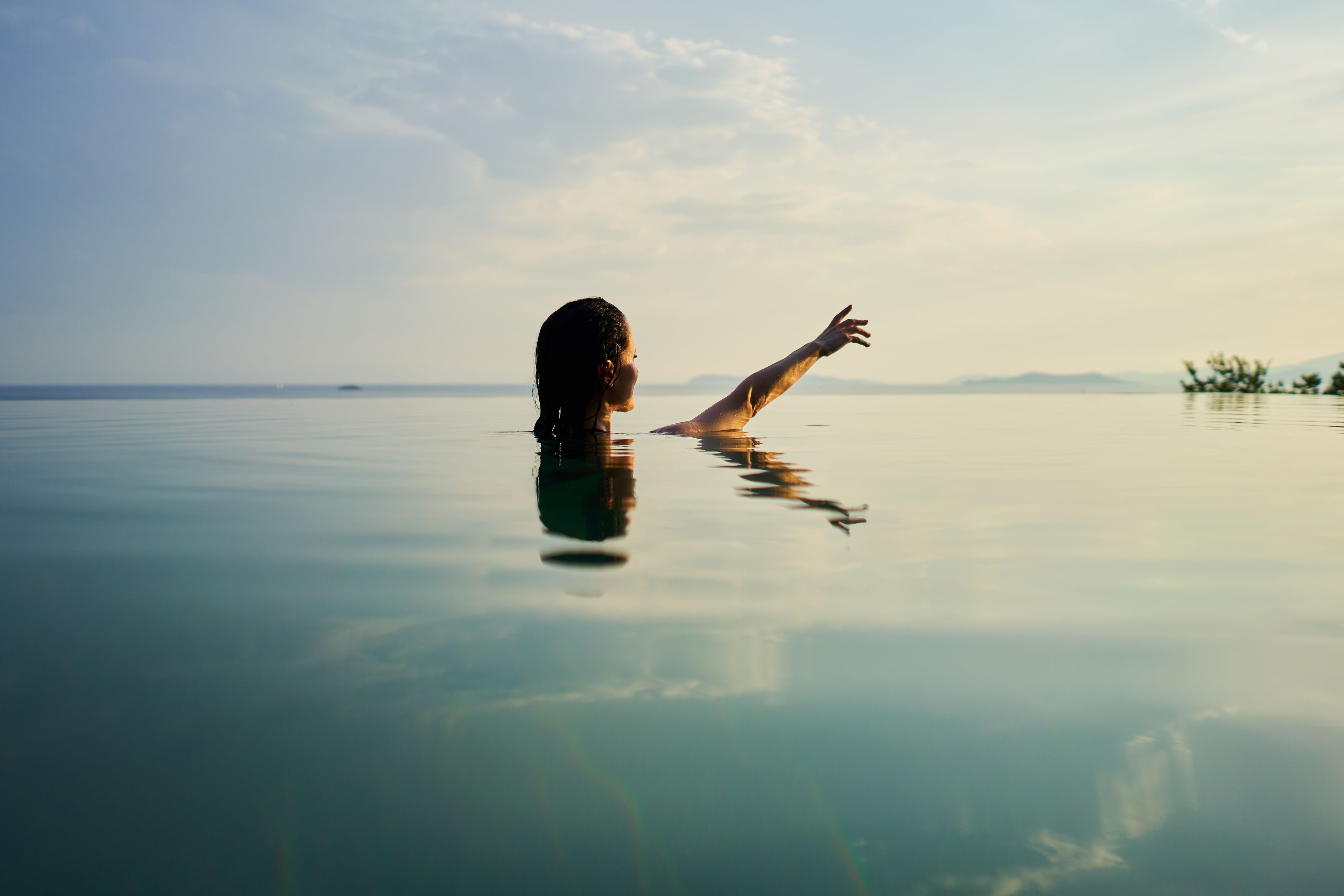 Iemand in water, met een heldere lucht.