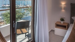 A room with a large window, a small table with a plant, and a white curtain.