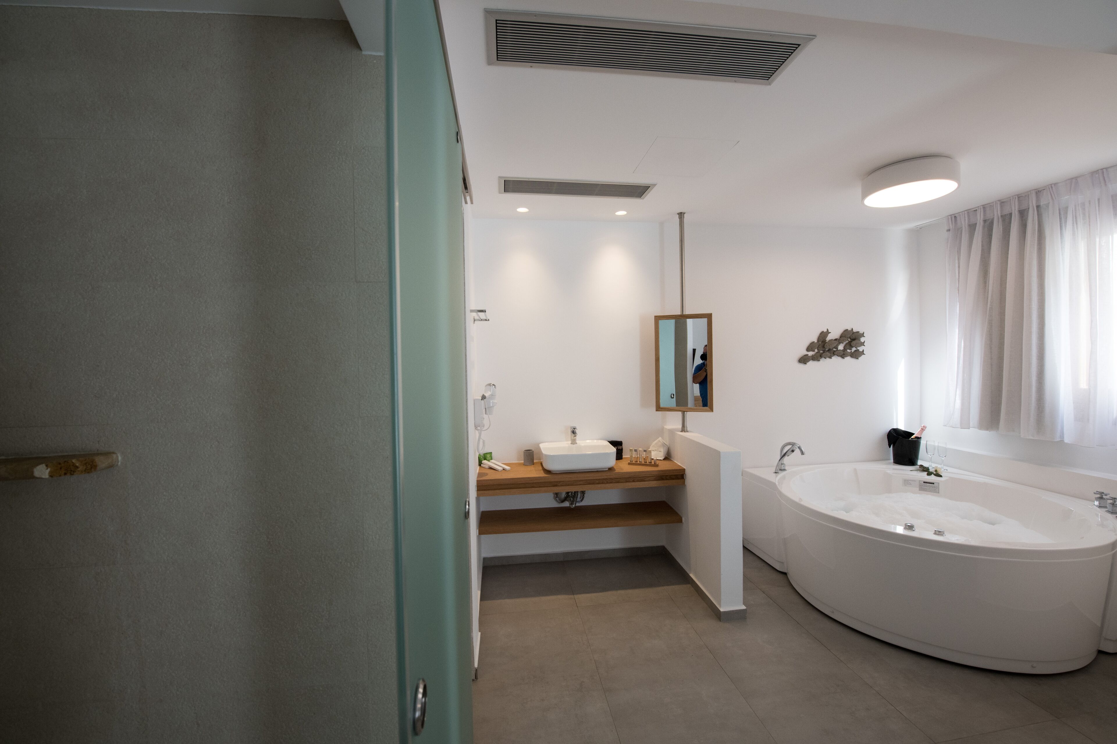 A modern bathroom with a freestanding bathtub, a vanity with a mirror, and a shower area.
