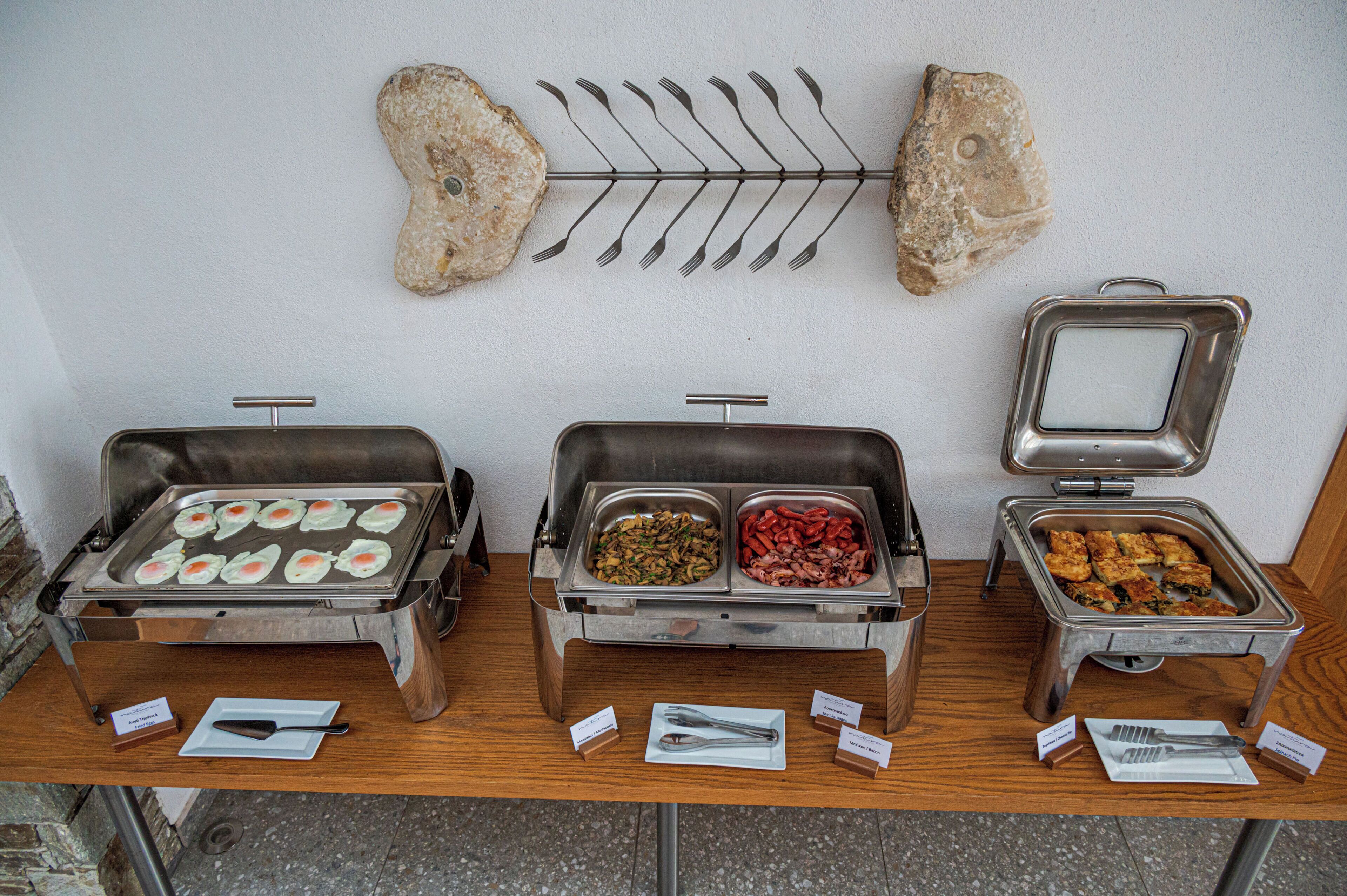 Montaje tipo buffet con diversos alimentos y cubiertos.