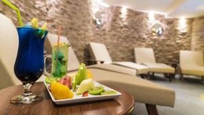 A room with a stone wall, a table with a drink and fruit, and a sofa. - Mirart Hotel Boutique & SPA Yalova (Yalova)