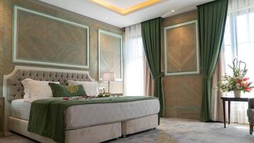 A spacious bedroom with a large bed, a nightstand, and a window with curtains.
