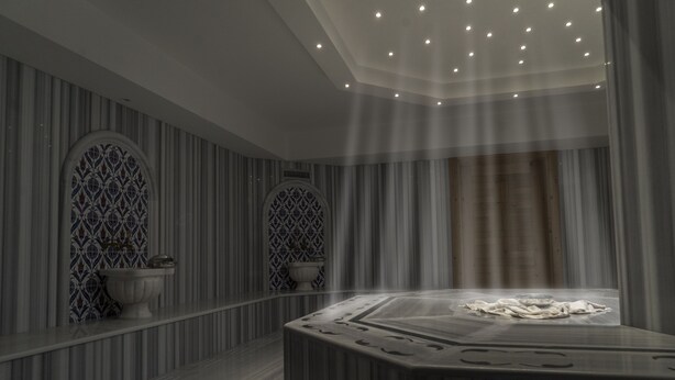A modern spa room with a central hot tub, striped walls, and decorative tiles. - Mirart Hotel Boutique & SPA Yalova (Yalova)
