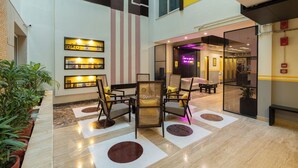 A lobby with a seating area, a reception desk, and a glass door entrance. - The Hosteller Delhi (New Delhi)
