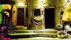 Ein Gebäude mit einer Steinfassade, zwei Rundbögen und einer Treppe, die zu einer oberen Ebene führt.