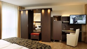 A hotel room with a bed, a desk, a television, and a wardrobe. - Hotel Simonshof Wolfsburg (Wolfsburg)