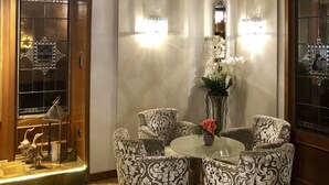 A room with a wooden ceiling, patterned chairs, a glass table, and a chandelier. - Hotel Simonshof Wolfsburg (Wolfsburg)