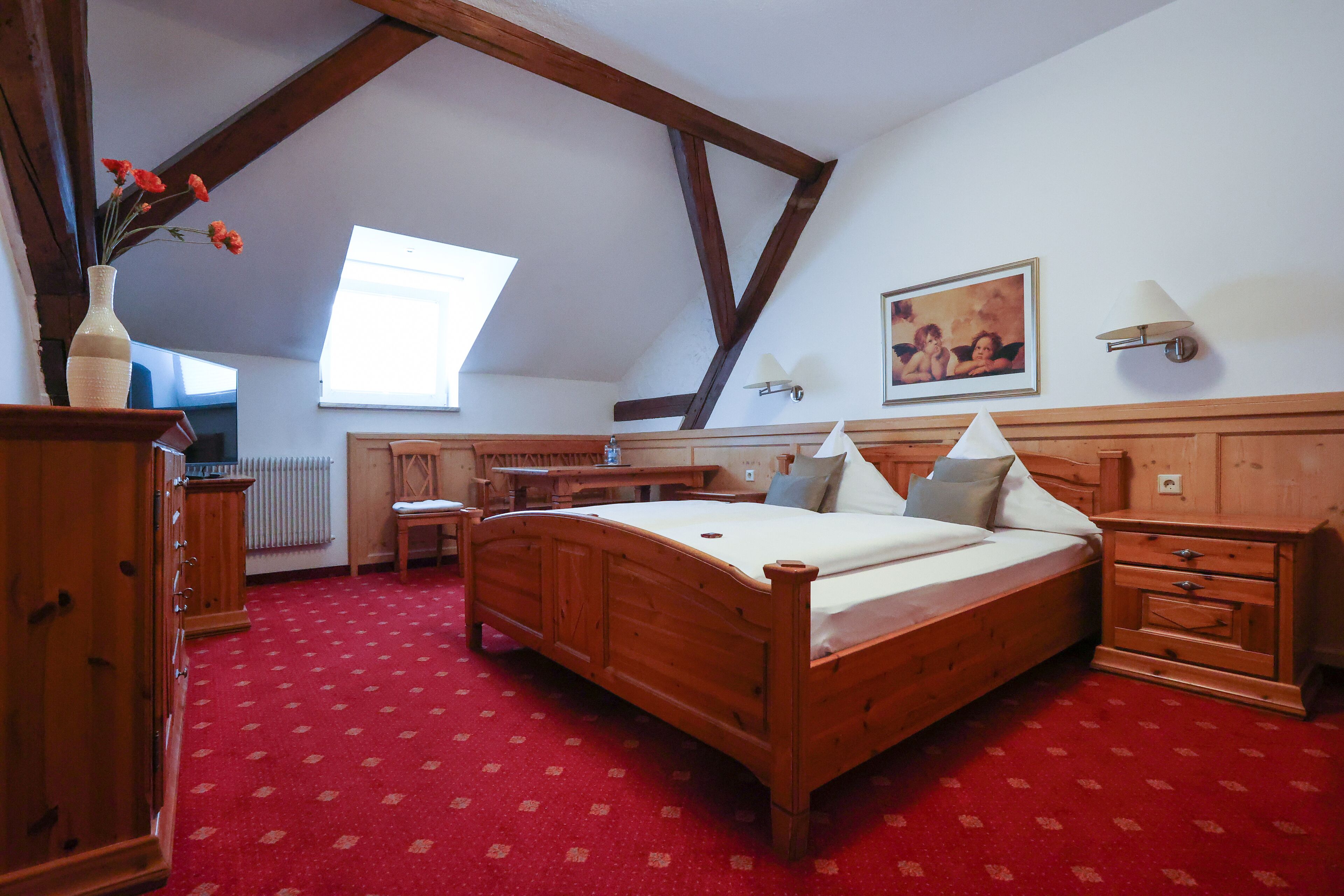 A bedroom with a wooden bed, a desk, a chair, and a radiator.