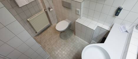 A modern bathroom with a toilet, sink, and towel rack.