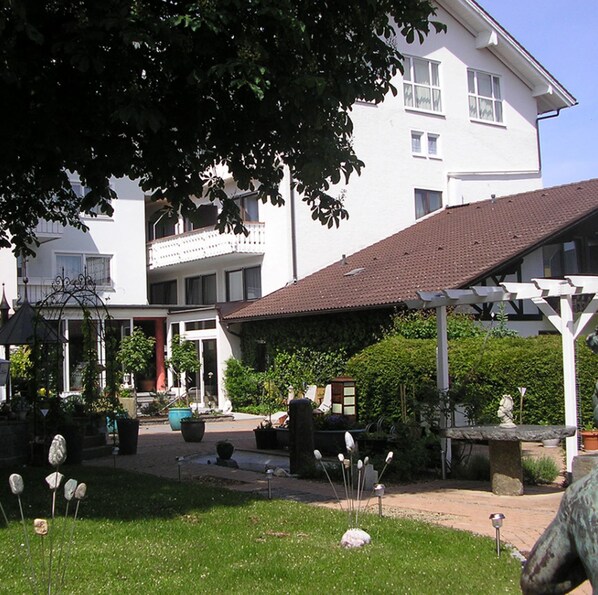 A white building with a balcony and a covered patio area. - Arthotel ANA Panorama, Trademark Collection by Wyndham (Marktoberdorf)