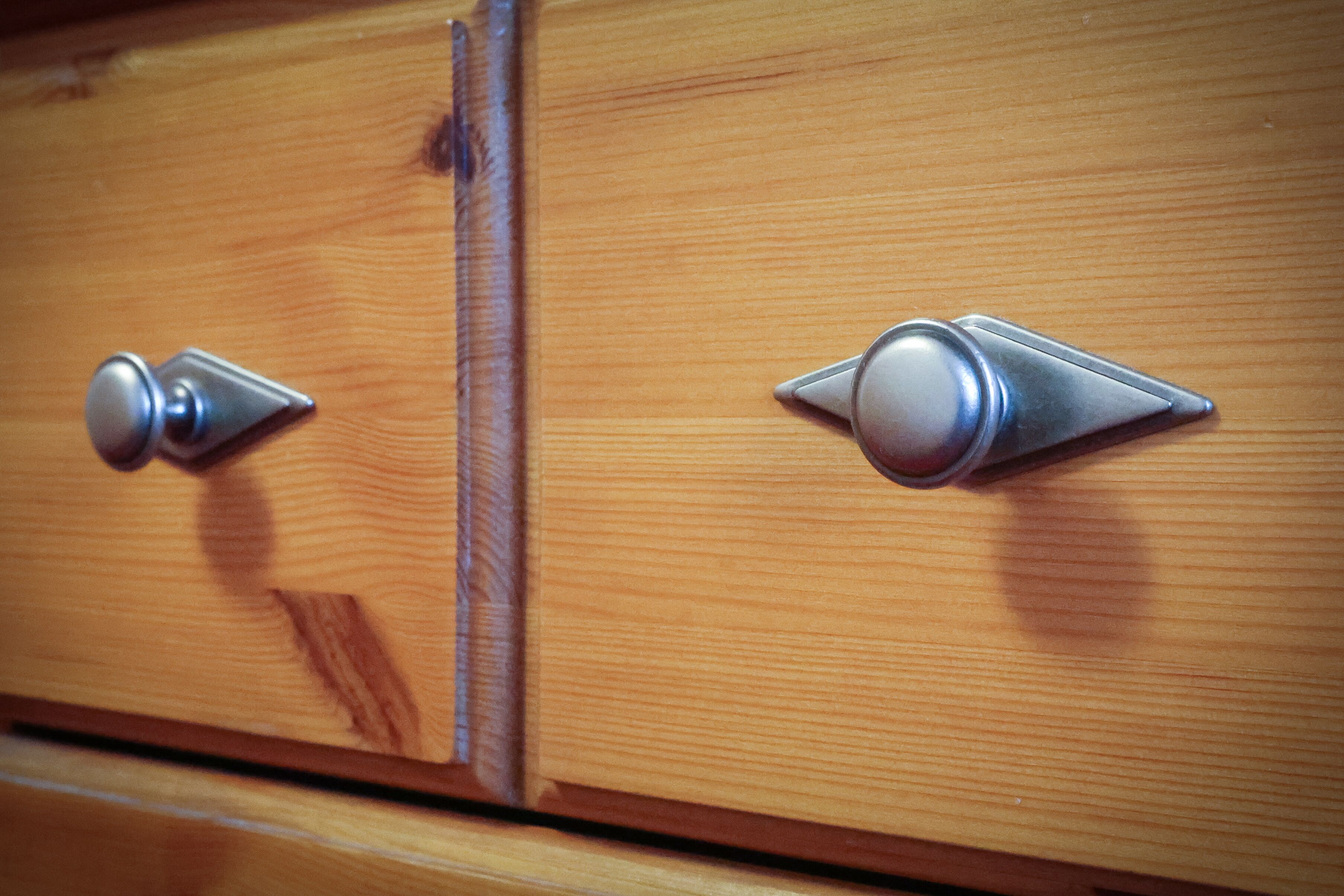 Een houten kast met twee metalen handgrepen.