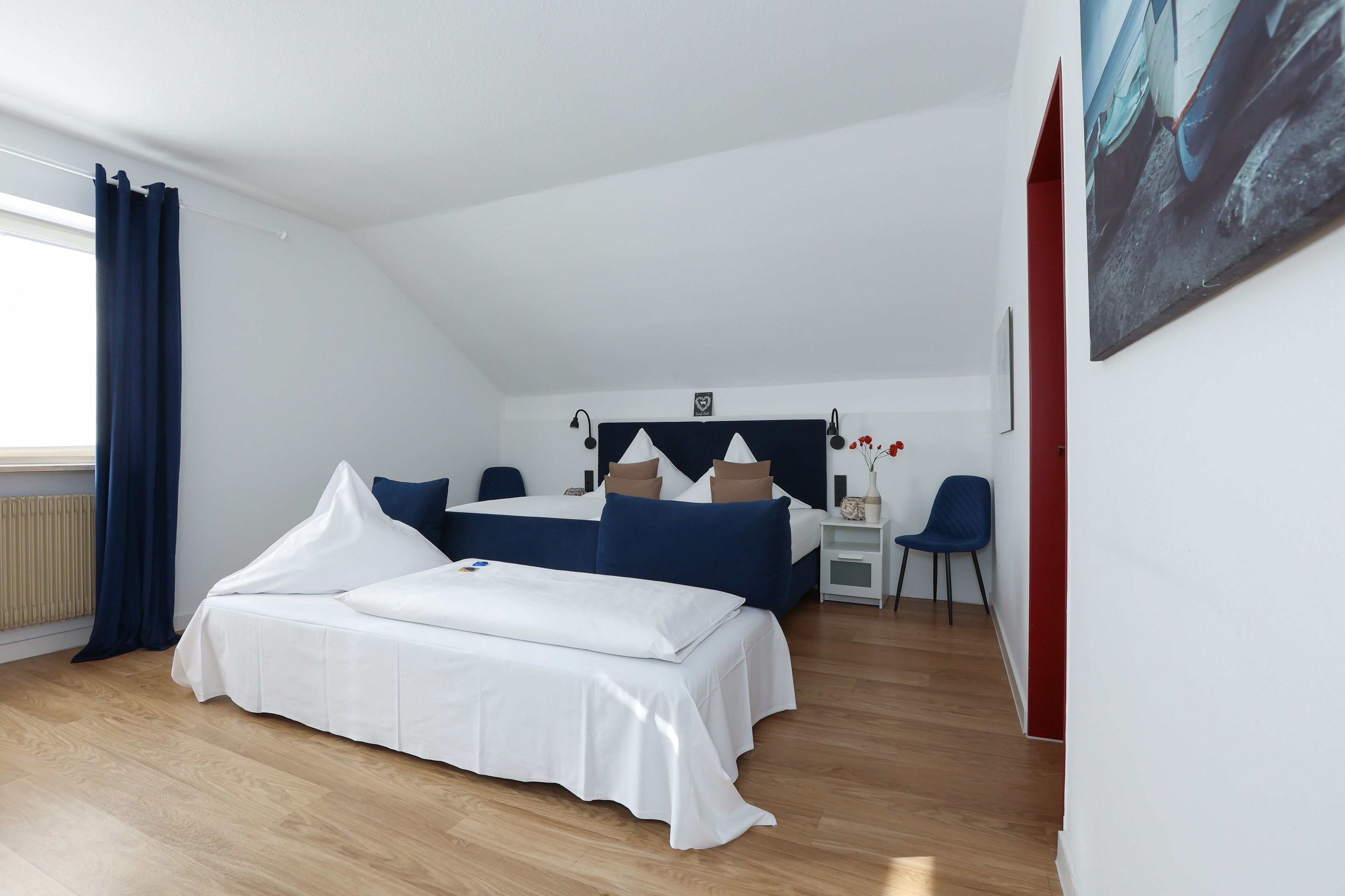A bedroom with a bed, a desk, and a chair.