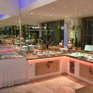 A buffet area with various food items and dishes displayed on counters. - Arthotel ANA Panorama, Trademark Collection by Wyndham (Marktoberdorf)