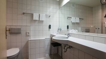 A modern bathroom with a toilet, sink, and mirror.