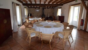 Comedor con mesas redondas cubiertas con manteles blancos y rodeadas de sillas de mimbre.