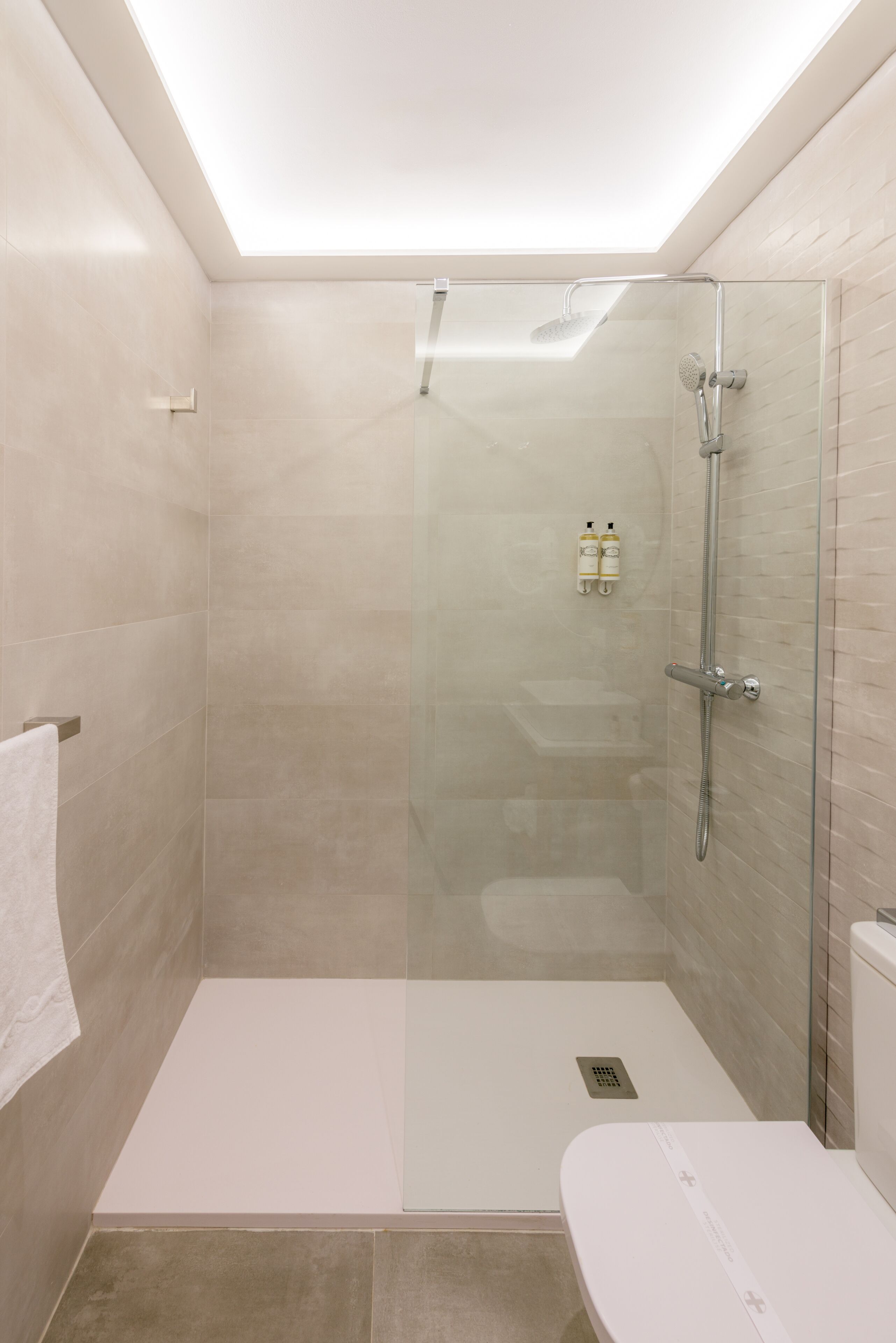 A modern bathroom with a glass-enclosed shower, a white toilet, and a white sink.