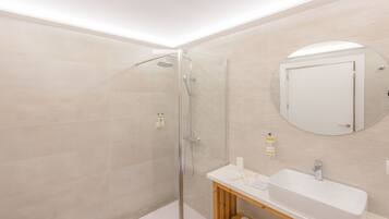 Une salle de bain moderne avec une douche à parois de verre, un lavabo blanc et un meuble-lavabo en bois.
