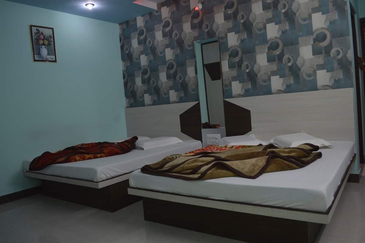 A hotel room with two beds, a large mirror, a wall with a geometric pattern, and a small picture on the wall.
