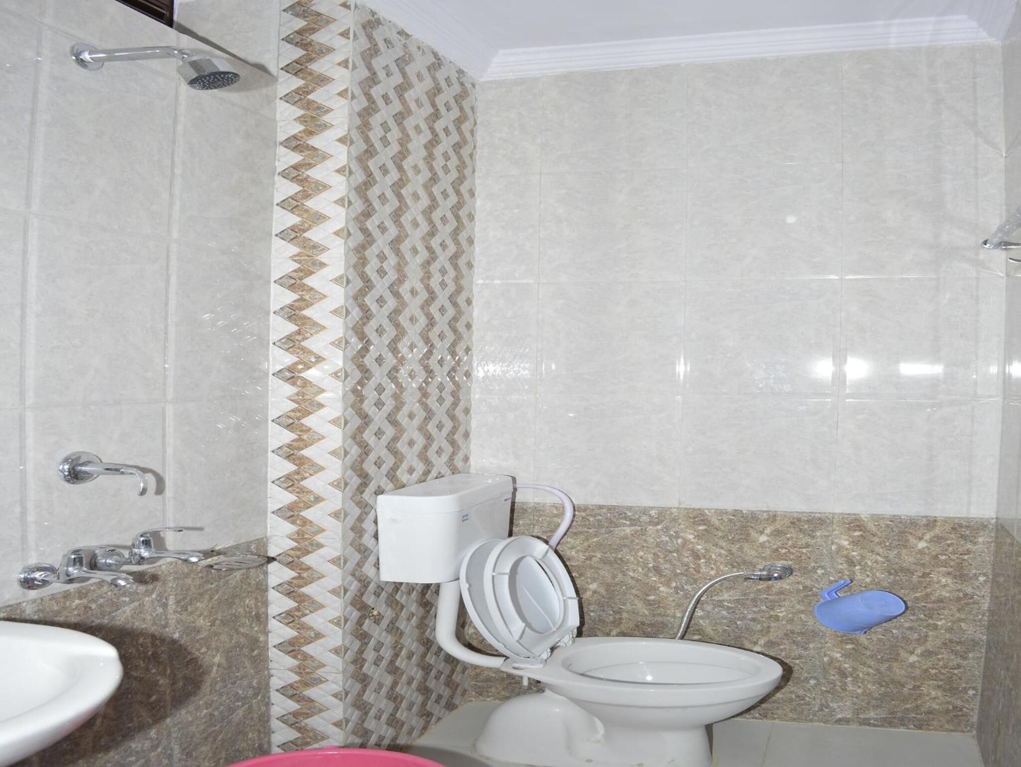 A bathroom with a shower, toilet, and sink.