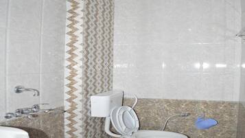 A bathroom with a shower, toilet, and sink.