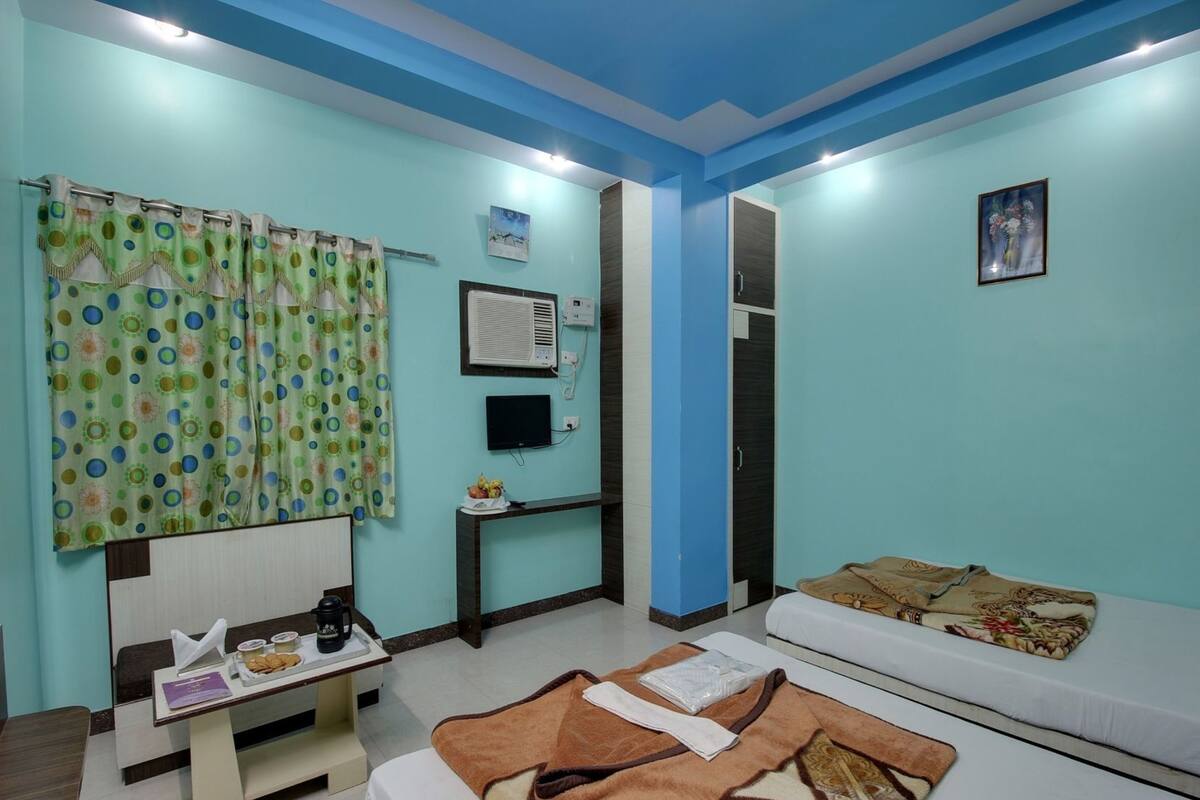 A room with a bed, a desk with a chair, a TV, and a wardrobe.