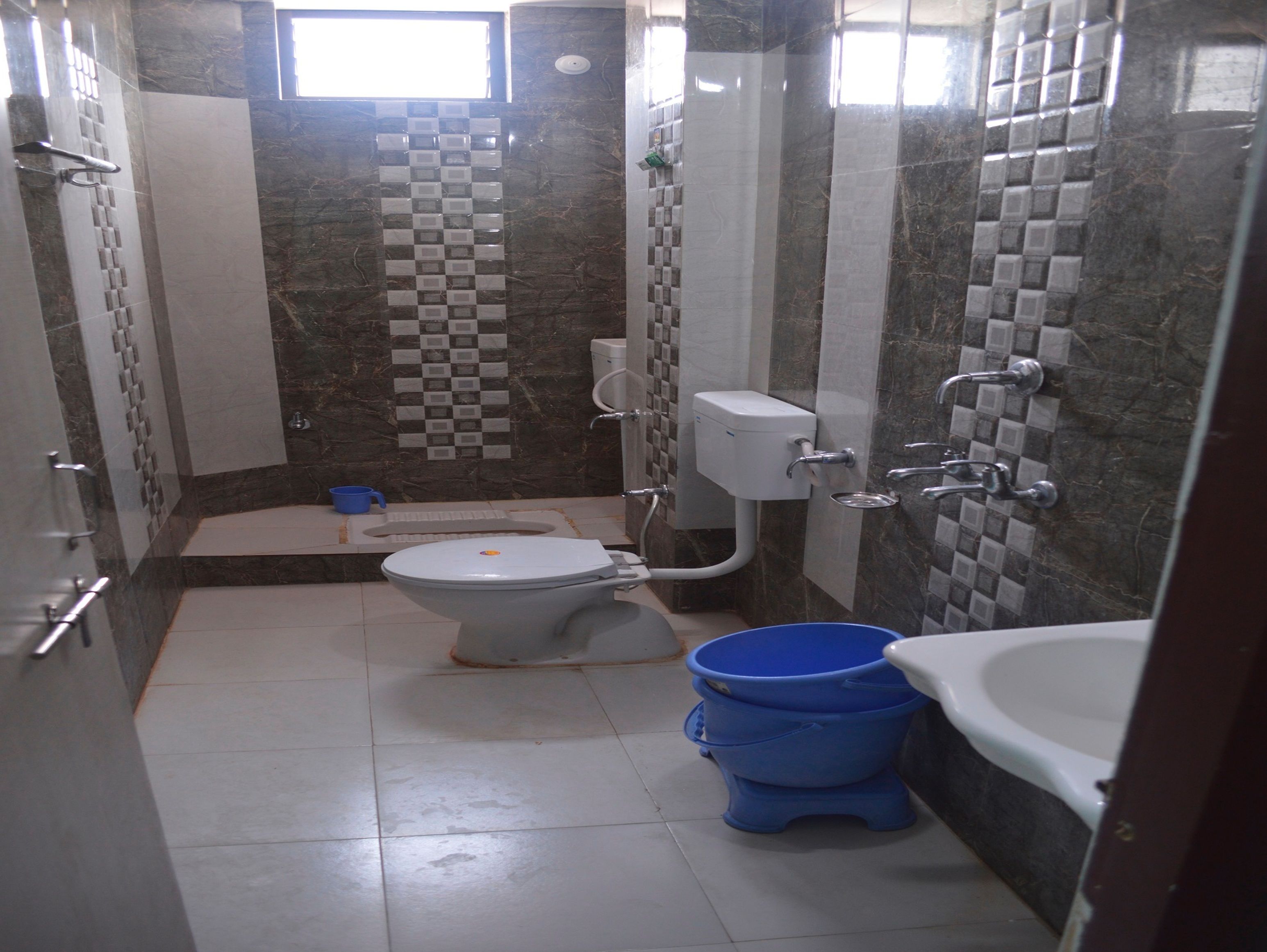 Een kleine badkamer met toilet, bidet en bad.