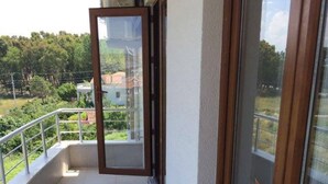 A balcony with a glass door leading to a terrace.
