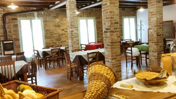 A rustic dining area with stone walls, wooden tables, and chairs. - Agriturismo di Sordiglio (Casina)