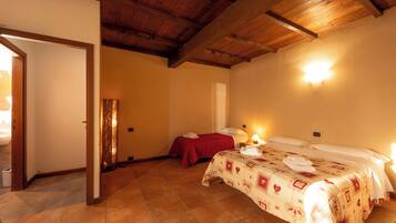 A room with two beds, a wooden ceiling, and a tiled floor.