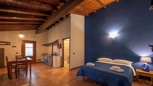 A room with a bed, a desk, a kitchenette, and a bathroom. - Agriturismo di Sordiglio (Casina)