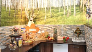 A breakfast buffet with various food items and a decorative wall with a forest view. - Pension & Ferienwohnung Schweinsberg (Medebach)
