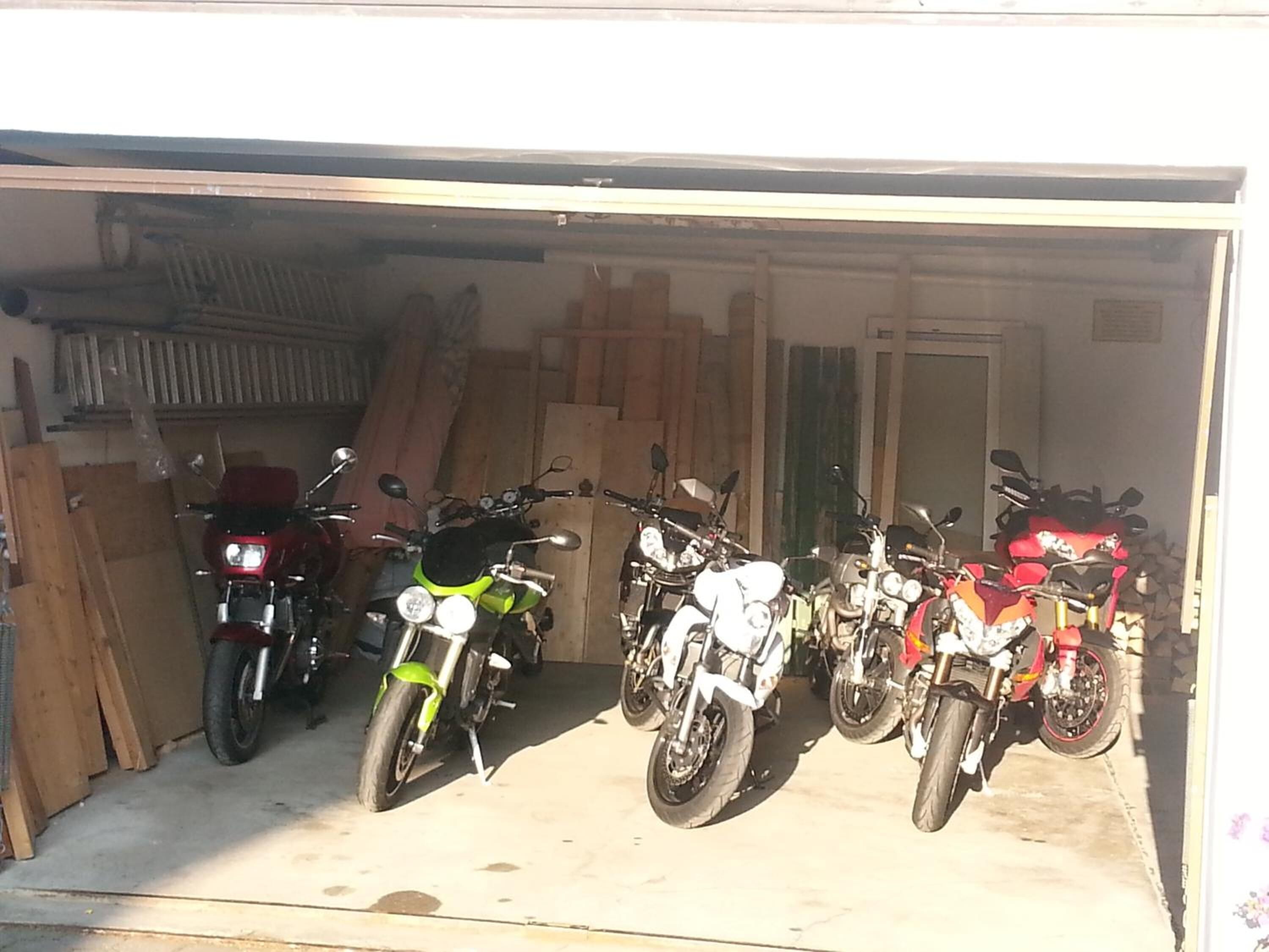 A garage with several motorcycles parked inside.