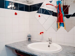 A bathroom with a white sink, a red faucet, and a striped soap dispenser. - Quiet 2-Room Villa with Terrace, Parking, and Pet-Friendly - Sleeps 5 (Narbonne-Narbonne Plage-Narbonne Plage)