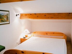 A bedroom with a wooden bed, a bedside table with a lamp, and a framed picture on the wall. - Quiet 2-Room Villa with Terrace, Parking, and Pet-Friendly - Sleeps 5 (Narbonne-Narbonne Plage-Narbonne Plage)