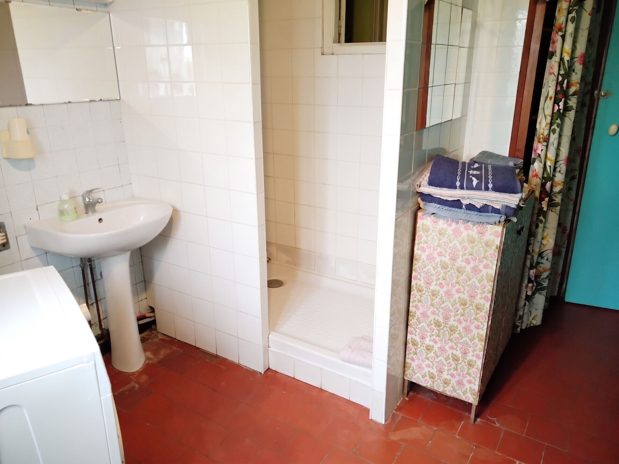 Une salle de bain avec un lavabo blanc, une douche et des toilettes.