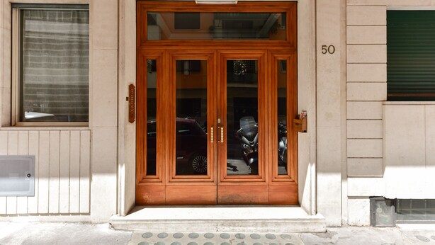 A wooden double door with glass panels, a number '50' on the wall, and a small step leading up to the entrance. - Domus Bella Roma (Rome)