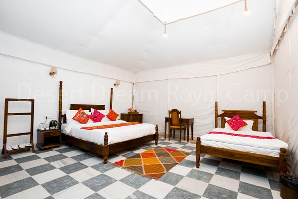 A room with two wooden beds, a small table, a chair, and a checkered floor.