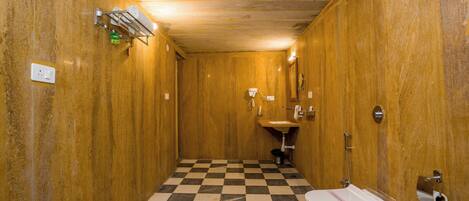 Ein kleines, schmales Badezimmer mit einem Schachbrettmuster-Boden, Holzwänden, einem Waschbecken und einer Toilette.