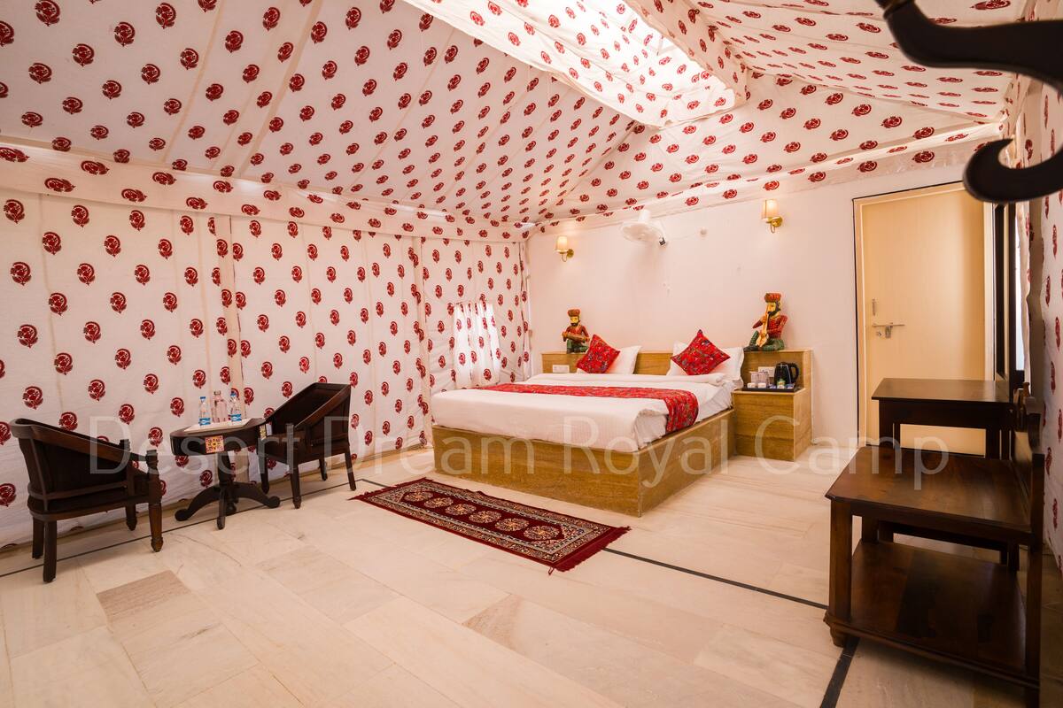 Een slaapkamer met een bed, nachtkastje, stoel en een houten tafel.